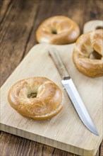 Fresh baked Bagels on a wooden table (selective focus, close-up shot)