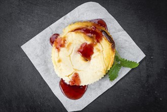 Fresh made Mini Cheesecake (with Sauce) on a vintage background (close-up shot)