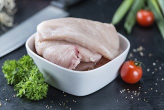 Slate slab with raw Chicken Cutlet (close-up shot)