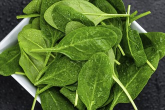 Portion of fresh Spinach as detailed close-up shot on a vintage slate slab (selective focus)