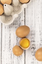 Some Raw Eggs on a vintage wooden table (selective focus, close-up shot)