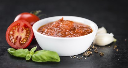 Fresh made Pasta Sauce (Tomato taste) on a vintage background (close-up shot)