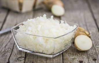 Chopped white onions on an old wooden table as detailed close-up shot, selective focus