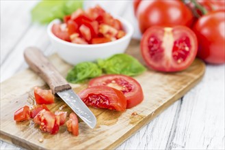 Homemade Diced Tomatoes on an wooden table (selective focus) as detailed close-up shot