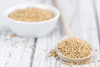 Mustard Seeds on rustic wooden background (close-up shot)