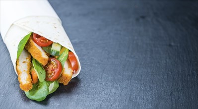 Chicken Wraps (selective focus) on a slate slab (close-up shot)