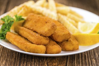 Portion of Fish Fingers (selective focus) on wooden background