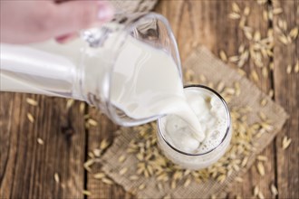 Healthy Oat Milk on a wooden table as detailed close-up shot (selective focus)