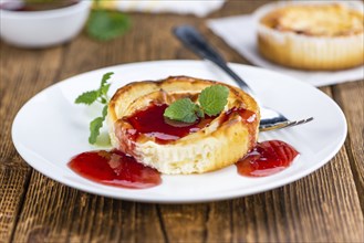 Cheesecake with Sauce on an old wooden table as detailed close-up shot (selective focus)