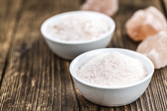 Pink Himalayan Salt on rustic wooden background (close-up shot)