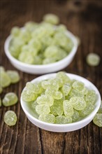 Portion of gummy candy (apple taste) on an old wooden table