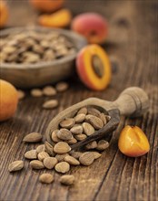 Vintage wooden table with a portion of shelled Apricot Kernels (close up shot, selective focus)