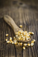 Dried Corn (detailed close-up shot, selective focus) on vintage wooden background