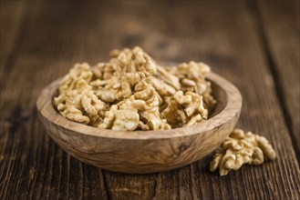 Walnuts (kernels) on an old wooden table as detailed close-up shot (selective focus)