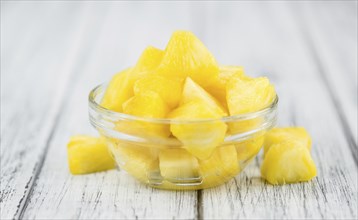 Sliced Pineapple on an old wooden table as detailed close-up shot, selective focus