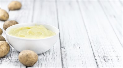 Potato Mash on rustic wooden background (close-up shot)