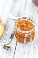 Wooden table with Peach Jam (selective focus, close-up shot)