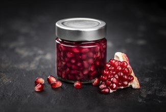 Healthy preserved Pomegranate seeds on a vintage slate slab (close-up shot, selective focus)