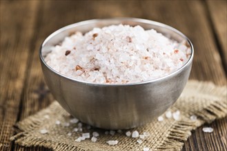 Himalayan Salt as high detailed close-up shot on a vintage wooden table (selective focus)