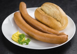 Portion of Sausages (Frankfurter) as detailed close up shot on a slate slab (selective focus)