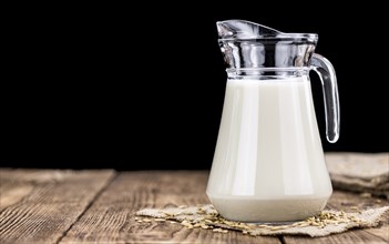 Wooden table with Oat Milk (detailed close-up shot, selective focus)