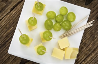 Cheese blocks with grapes as close-up shot (selective focus, partyfood)