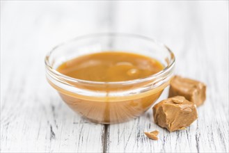 Caramel Sauce on a vintage background as detailed close-up shot (selective focus)