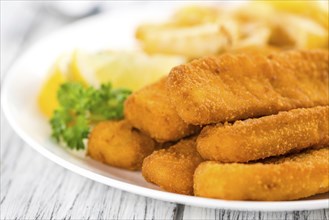 Some fried Fish Sticks (selective focus) on an old wooden table