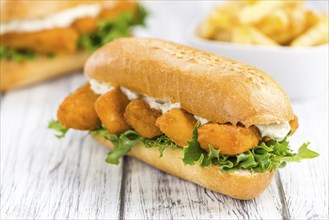 Fresh made Snack (Sandwich with Fish Sticks) on an old wooden table