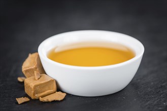 Syrup (Caramel taste) on a vintage slate slab (close-up shot, selective focus)