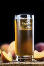 Peach ice tea (selective focus) on an old wooden table (close-up shot)