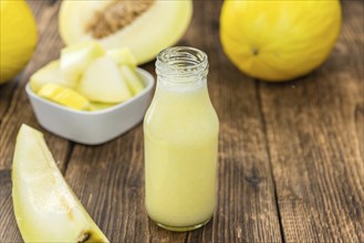 Fresh made Honeydew Melon smoothie (close-up shot, selective focus) on a wooden table