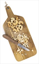 Portion of chopped Cashew nuts isolated on pure white background (detailed close-up shot)