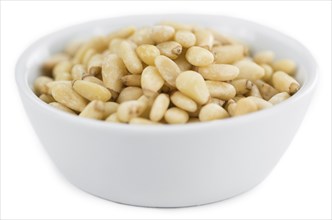 Portion of Pine Nuts (as close-up shot) isolated on white background