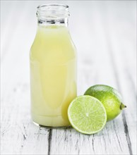 Fresh made Fresh Lime Juice on an old and rustic wooden table (selective focus, close-up shot)