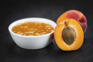 Portion of Apricot Jam on a rustic slate slab (selective focus, close-up shot)