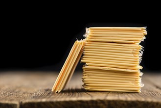 Cheese (sliced) on an old wooden table as detailed close-up shot (selective focus)