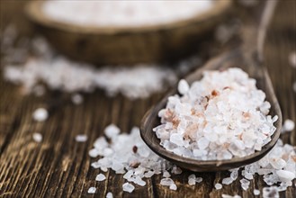 Himalayan Salt as high detailed close-up shot on a vintage wooden table (selective focus)