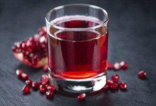 Some fresh Pomegranate juice on a vintage slate slab (selective focus, close-up shot)