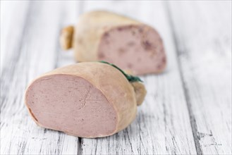 German Leberwurst on an old wooden table as detailed close-up shot (selective focus)