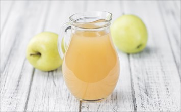 Apple Juice on an old wooden table as detailed close-up shot (selective focus)