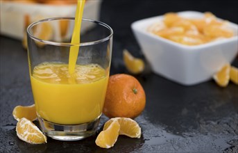 Homemade Tangerine Juice (close-up shot, selective focus) on a rustic background