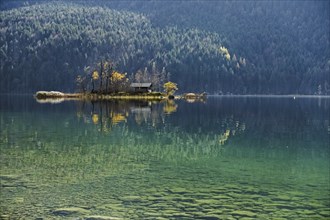 Island with wooden hut in autumn in Lake Eibsee lake in the Bavarian Alps