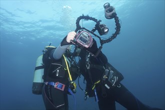 Two divers take a photo, selfie, underwater with a camera. Dive site Marine reserve Cap de Creus,