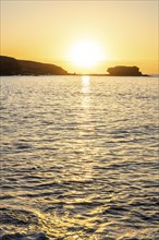 View of the sunrise over the Atlantic. View over a stone beach on a volcanic island. Cold lava