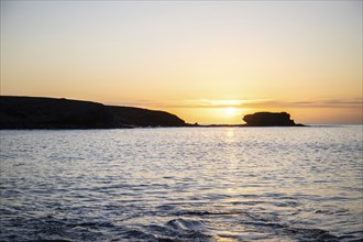 View of the sunrise over the Atlantic. View over a stone beach on a volcanic island. Cold lava