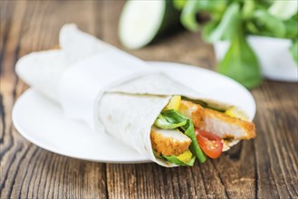 Chicken Wrap (detailed close-up shot, selective focus) on wooden background