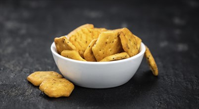 Portion of mixed Snacks on dark background (detailed close up shot, selective focus)