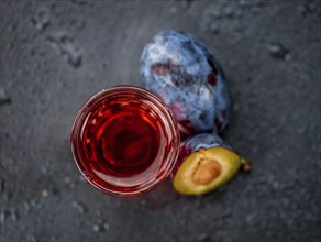 Some Plum Liqueur on a vintage slate slab, selective focus