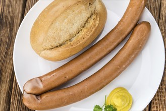 Sausages (Frankfurter) on rustic wooden background (close-up shot)